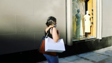 woman in white shirt and blue denim jeans standing in front of mirror