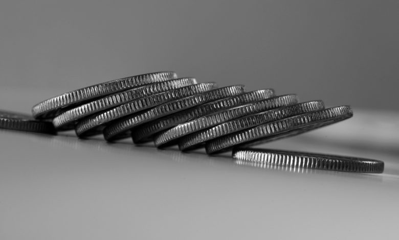 a stack of silver coins sitting on top of a table
