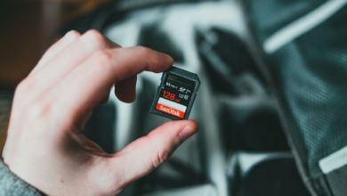 person holding black and red nintendo game cartridge