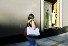 woman in white shirt and blue denim jeans standing in front of mirror