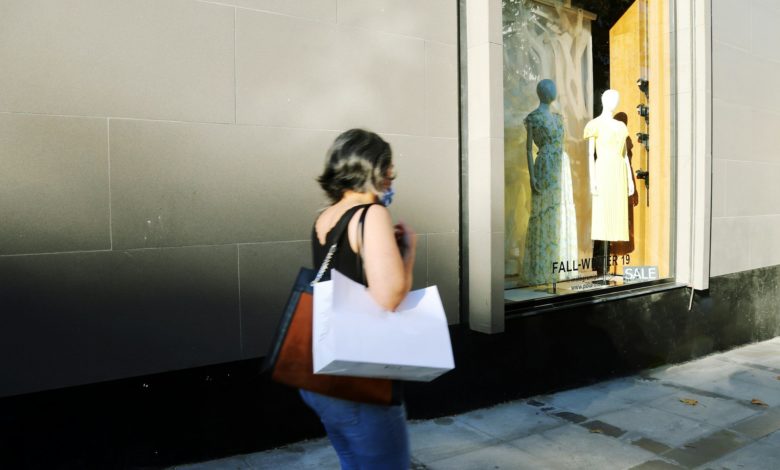 woman in white shirt and blue denim jeans standing in front of mirror