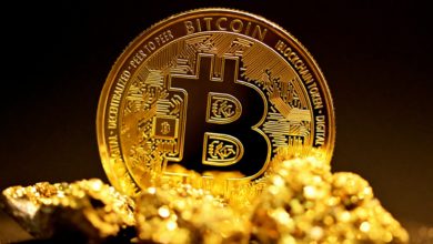 a bitcoin sitting on top of a pile of gold nuggets