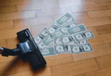 a pile of money sitting on top of a wooden floor