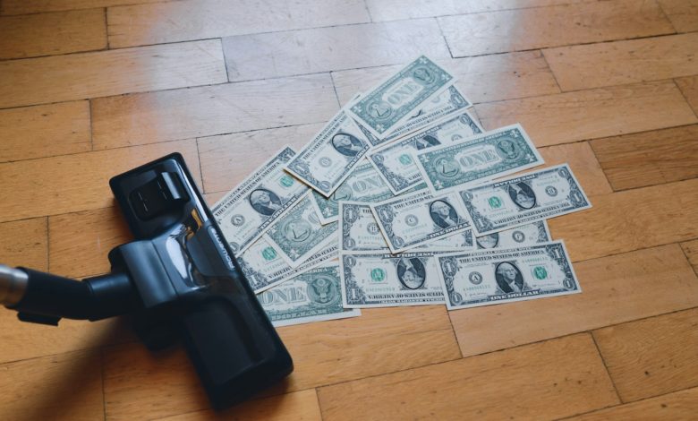 a pile of money sitting on top of a wooden floor