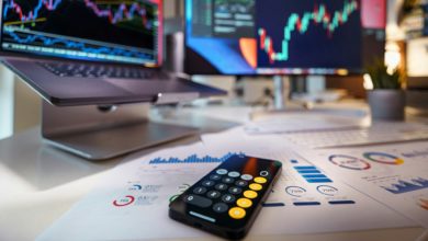 smartphone calculator on desk with financial charts behind